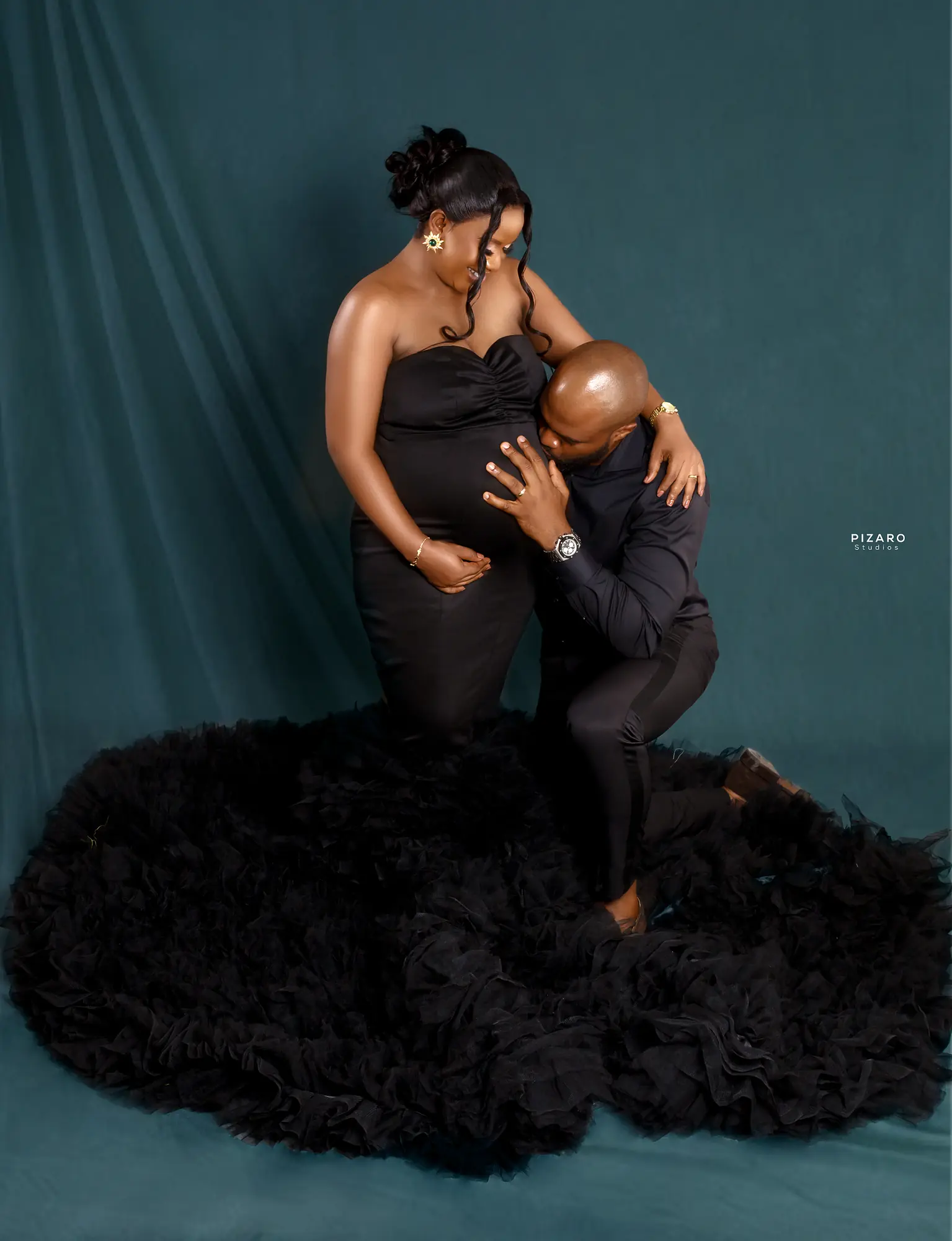 Pizaro Studios maternity session — expecting couple on a deep teal backdrop