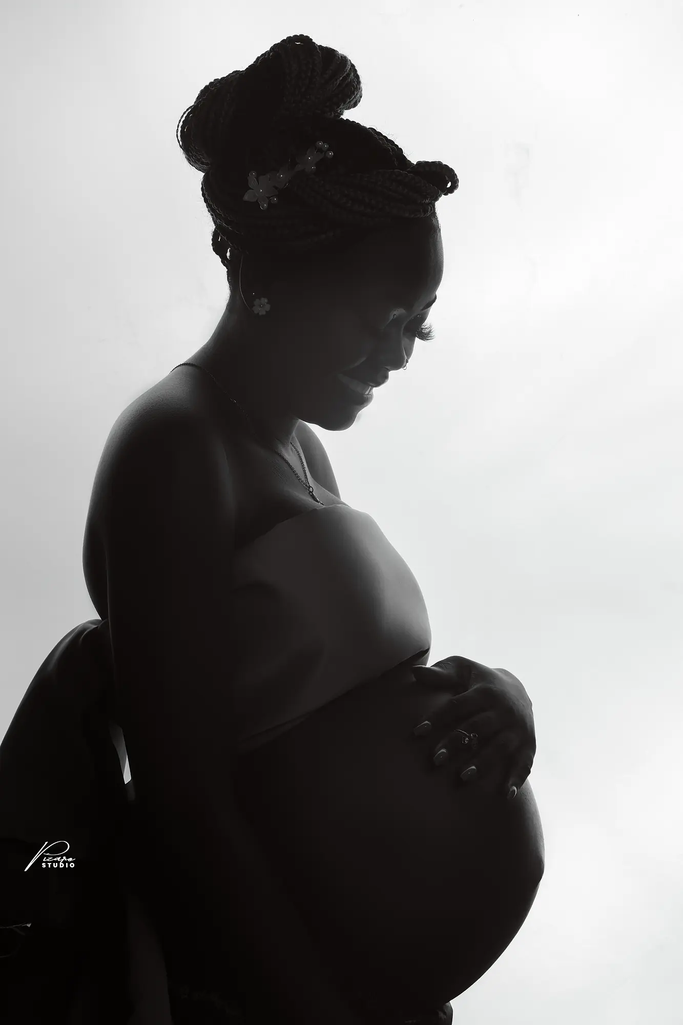 Pizaro Studios maternity session — soft backlit black-and-white profile portrait